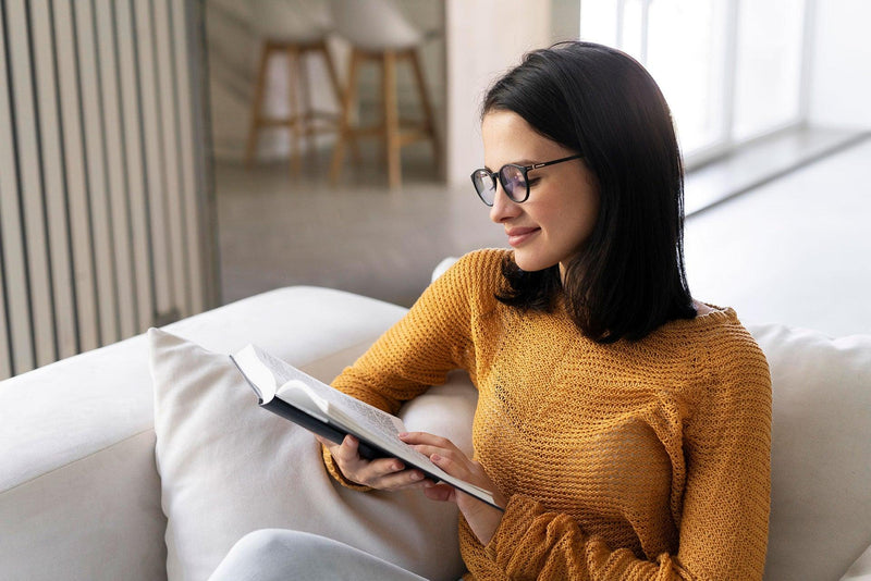  young-woman-reading-from-book-home - Tolerant Planet